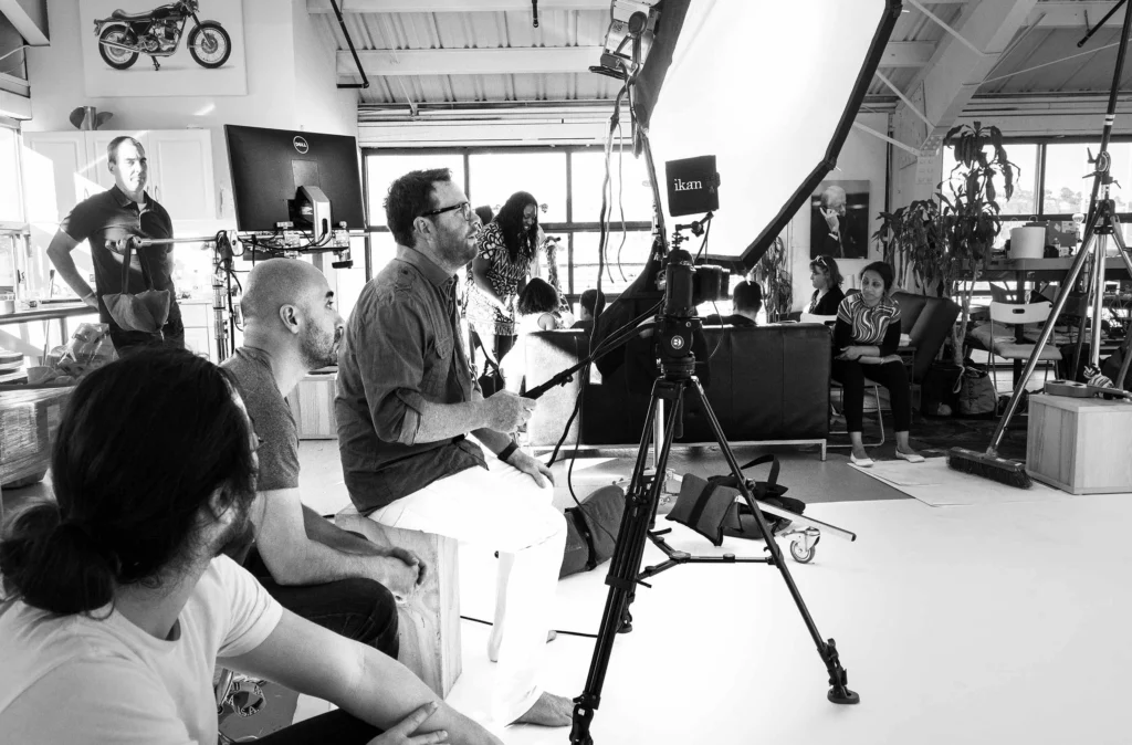 Executive portrait photographer directing a commercial shoot with crew and lighting setup