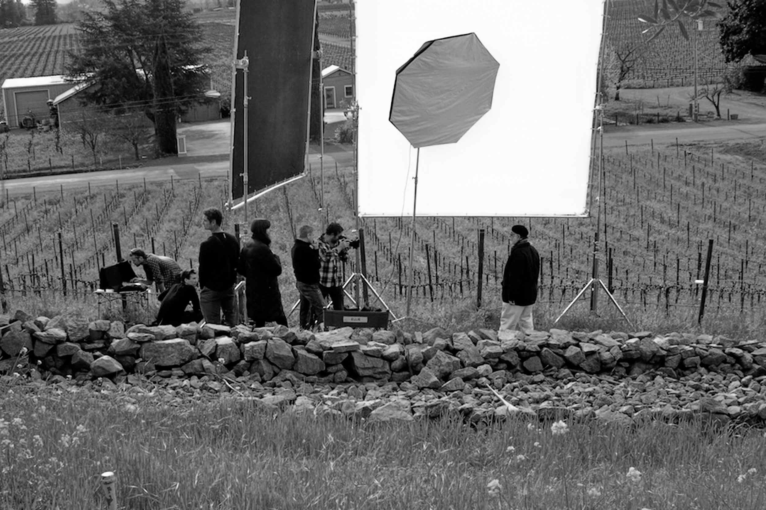 Film production set with crew, lighting equipment, and large diffusion panel during a commercial shoot