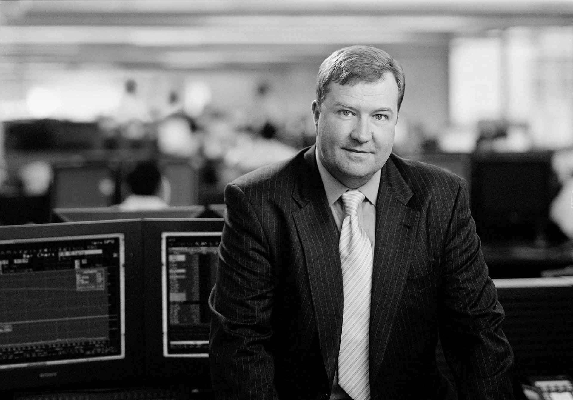 Black and white executive portrait of a finance leader on a trading floor in Copenhagen – Executive Portrait Photographer Copenhagen