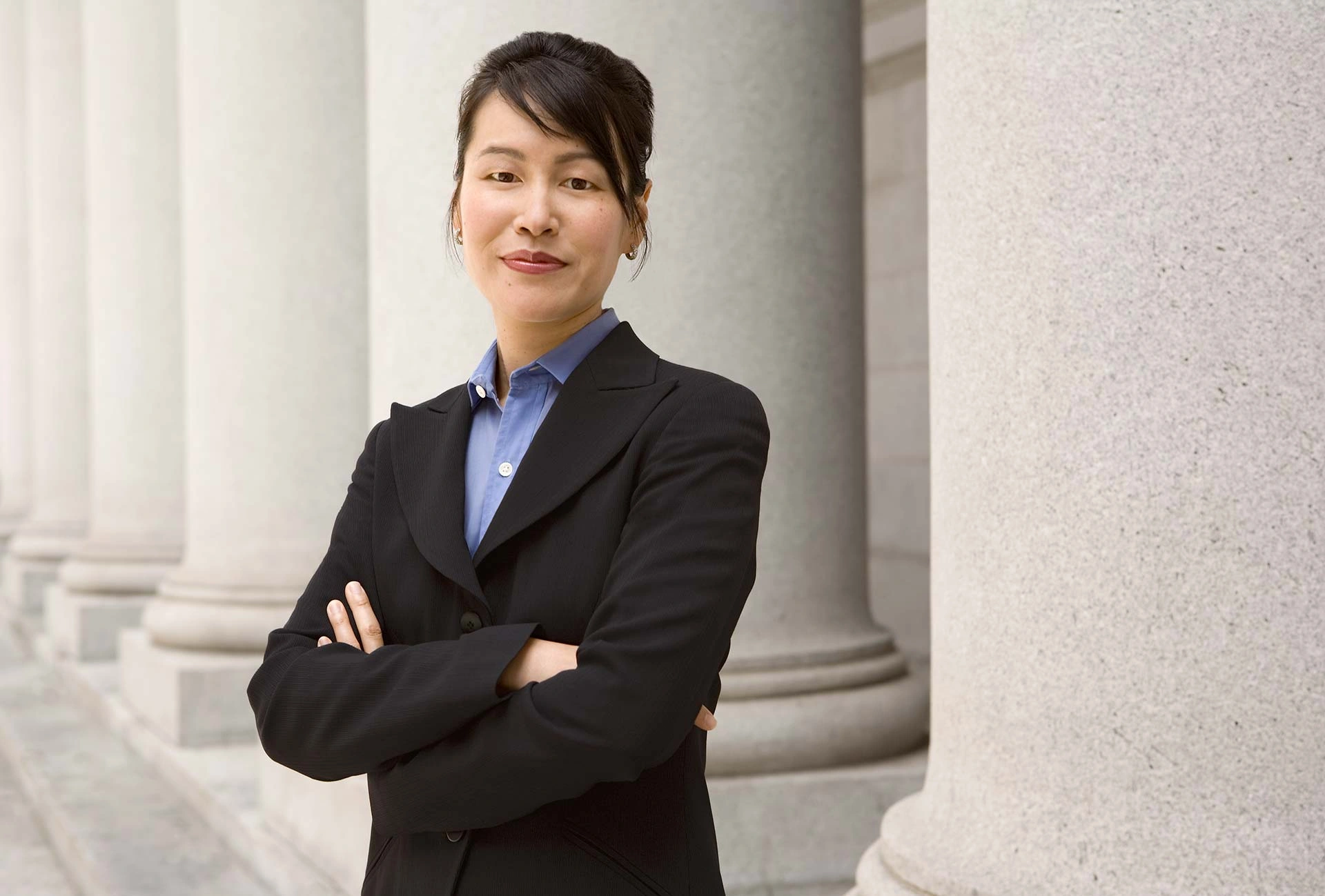 Executive portrait of a legal professional standing before stone columns in Copenhagen – Executive Portrait Photographer Copenhagen